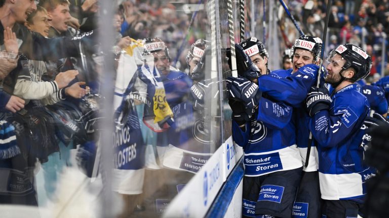 Ambri's Dario Buergler and Andre Heim, from left, and teammates celebrate with fans after the game between Switzerland's HC Ambri-Piotta and Finland's IFK Helsinki, at the 94th Spengler Cup ice hockey tournament in Davos, Switzerland, Wednesday Dec. 28, 2022. (Gian Ehrenzeller/Keystone via AP)