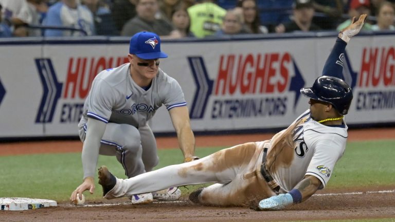 Toronto Blue Jays' Matt Chapman, left, loses the ball as Tampa Bay Rays' Wander Franco, right, slides safely into third base on Isaac Paredes' single to center field during the third inning of a baseball game Monday, May 22, 2023, in St. Petersburg, Fla. (Steve Nesius/AP)