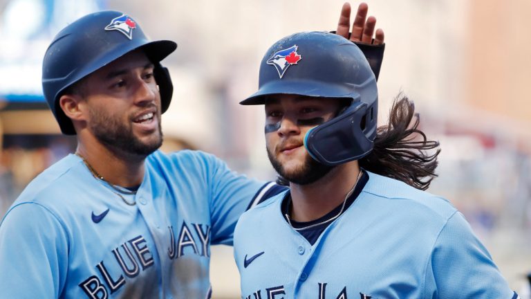 Toronto Blue Jays' George Springer, left, congratulates Bo Bichette for his two-run home run against the Minnesota Twins during the third inning of a baseball game Friday, May 26, 2023, in Minneapolis. (Bruce Kluckhohn/AP)