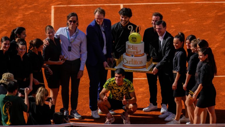 Carlos Alcaraz, of Spain, center down, poses with a cake for his 20th birthday after his victory over Borna Coric, of Croatia, during men's semifinal at the Madrid Open tennis tournament in Madrid, Spain, Friday, May 5, 2023. (AP Photo/Manu Fernandez)