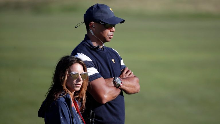 Tiger Woods, top, assistant United States team captain, and his associate Erica Herman, watch play on the 17th hole during the final round of the Presidents Cup golf tournament at Liberty National Golf Club in Jersey City, N.J., Sunday, Oct. 1, 2017. (Julio Cortez/AP)