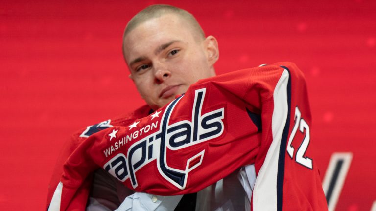 Washington Capitals 20th pick Ivan Miroshnichenko puts on his jersey during the first round of the 2022 NHL Draft Thursday, July 7, 2022 in Montreal. (Ryan Remiorz/CP)