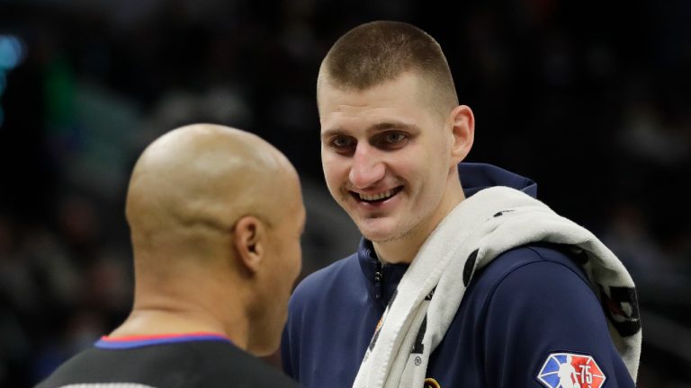 Denver Nuggets' Nikola Jokic, right, laughs with an official during the second half of an NBA basketball game against the Milwaukee Bucks, Sunday, Jan. 30, 2022, in Milwaukee. (Aaron Gash/AP)