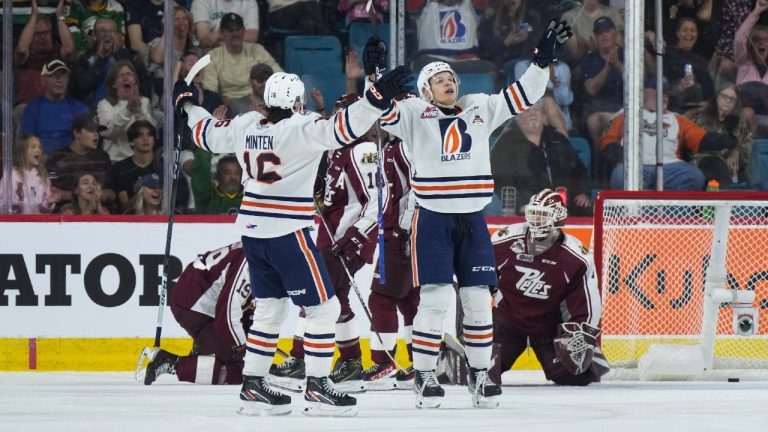 Kamloops Blazers' Jakub Demek, front right, and Fraser Minten celebrate Demek's goal against Peterborough Petes goalie Liam Sztuska, back right, during second period Memorial Cup hockey action, in Kamloops, B.C., on Sunday, May 28, 2023. (Darryl Dyck/CP)