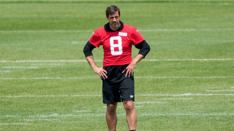 New York Jets quarterback Aaron Rodgers (8) stands on the field alone after performing weighted drills that led to favoring his lower legs at the NFL football team's practice facility, Tuesday, May 23, 2023, in New York. (John Minchillo/AP)