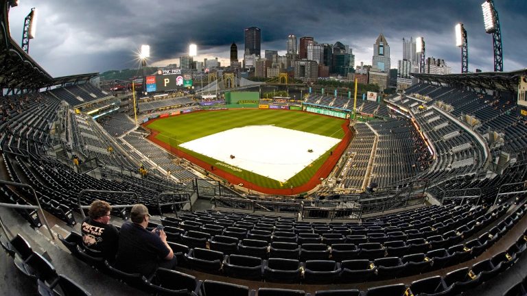 Fans sit under cover in the upper deck of PNC Park as the field remains covered during a rain delay before a baseball game. (AP Photo/Gene J. Puskar)