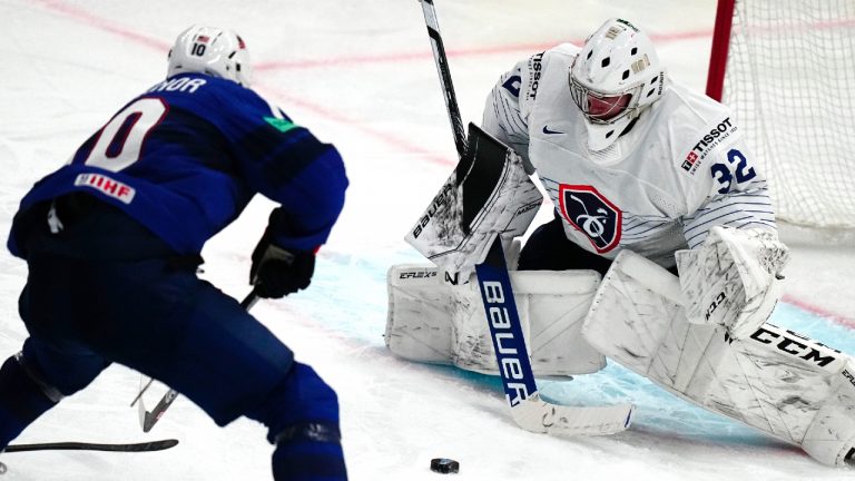 United States Drew O'Connor, left, scores his side's fifth goal past France's goalie Quentin Papillon during the group A match between United States and France at the ice hockey world championship in Tampere, Finland, Sunday, May 21, 2023. (Pavel Golovkin/AP)