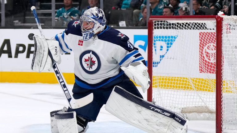 Winnipeg Jets goaltender Connor Hellebuyck blocks a San Jose Sharks shot during the first period of an NHL hockey game Tuesday, March 28, 2023, in San Jose, Calif. (Tony Avelar/AP)