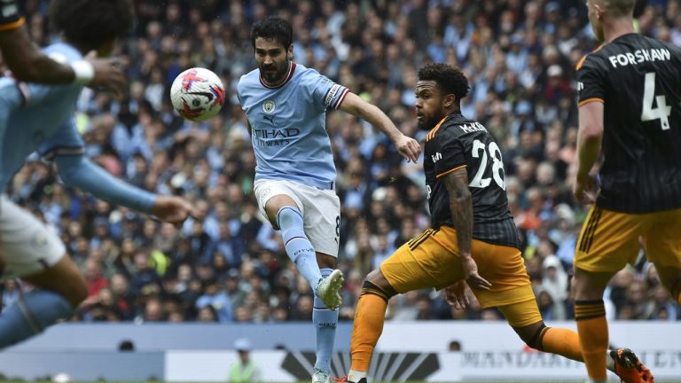 Manchester City's Ilkay Gundogan kicks the ball in an attempt to score, challenged by Leeds United's Weston McKennie during the English Premier League soccer match between Manchester City and Leeds United at Etihad stadium in Manchester, England, Saturday, May 6, 2023. (Rui Vieira/AP)