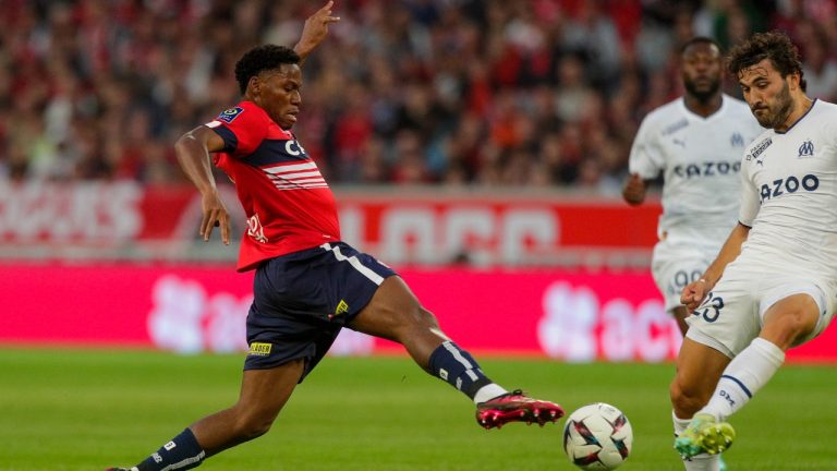 Lille's Jonathan David, left, duels for the ball with Marseille's Sead Kolasinac during the French League One soccer match between Lille and Marseille at the Pierre Mauroy stadium in Lille, France, Saturday, May 20, 2023. (Michel Spingler/AP)