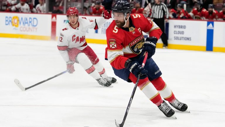 Florida Panthers defenseman Aaron Ekblad (5) skates with the puck as Carolina Hurricanes center Jesperi Kotkaniemi pursues during the first period of an NHL hockey game, Thursday, April 13, 2023, in Sunrise, Fla. (Lynne Sladky/AP)