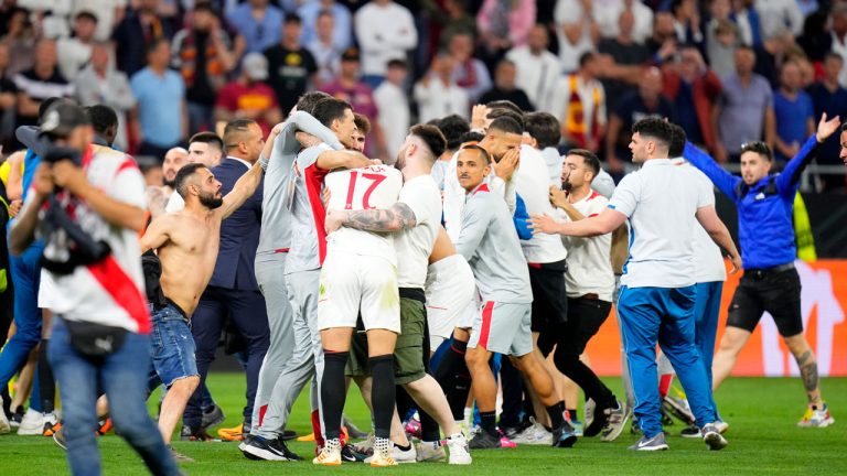 Sevilla fans join the players celebrating on the pitch after winning the Europa League final soccer match between Sevilla and Roma, at the Puskas Arena in Budapest, Hungary, Wednesday, May 31, 2023. Sevilla defeated Roma 4-1 in a penalty shootout. (Petr David Josek/AP)