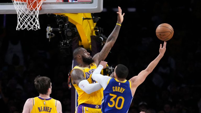 Golden State Warriors guard Stephen Curry, right, shoots as Los Angeles Lakers forward LeBron James, center, and guard Austin Reaves defend during the second half in Game 4 of an NBA basketball Western Conference semifinal. (Marcio Jose Sanchez/AP)