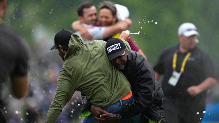 Canadian professional golfer Adam Hadwin is stopped by a security guard while he tries to celebrate after Nick Taylor won the Canadian Open in Toronto on Sunday, June 11, 2023. (CP)