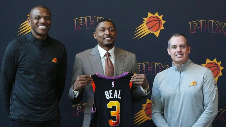 New Phoenix Suns guard Bradley Beal is flanked by Suns president of basketball operations and general manager James Jones and head coach Frank Vogel as Beal holds up a new Suns jersey during an NBA basketball news conference Thursday, June 29, 2023, in Phoenix. (Ross D. Franklin/AP Photo)