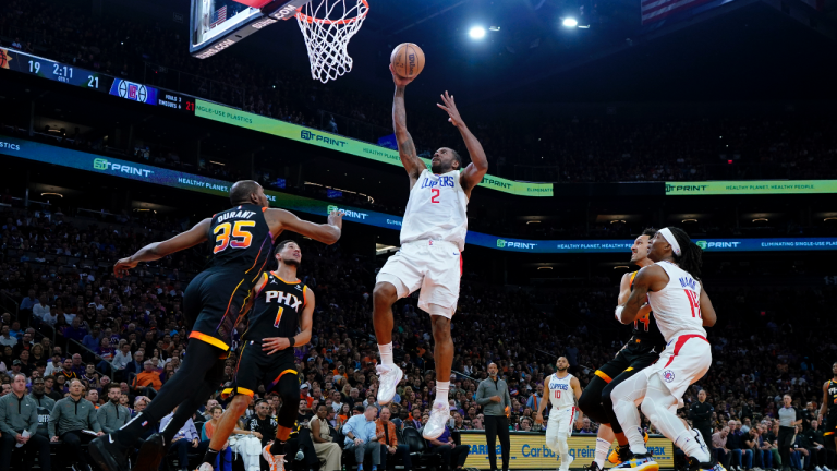 Los Angeles Clippers forward Kawhi Leonard (2) shoots as Phoenix Suns forward Kevin Durant (35) looks on during the first half of Game 2 of a first-round NBA basketball playoff series, Tuesday, April 18, 2023, in Phoenix. (AP Photo/Matt York