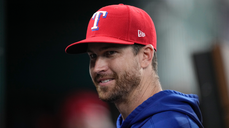 Texas Rangers pitcher Jacob deGrom talks with teammates in the dugout before a baseball game against the St. Louis Cardinals, Tuesday, June 6, 2023, in Arlington, Texas. (AP Photo/Tony Gutierrez)