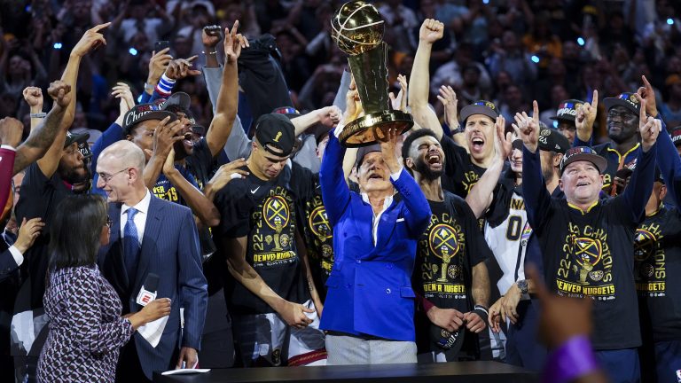 Denver Nuggets owner Stan Kroenke, center, holds up the Larry O'Brien NBA Championship Trophy after the team's victory over the Miami Heat in Game 5 of basketball's NBA Finals, Monday, June 12, 2023, in Denver. (AP Photo/Jack Dempsey)