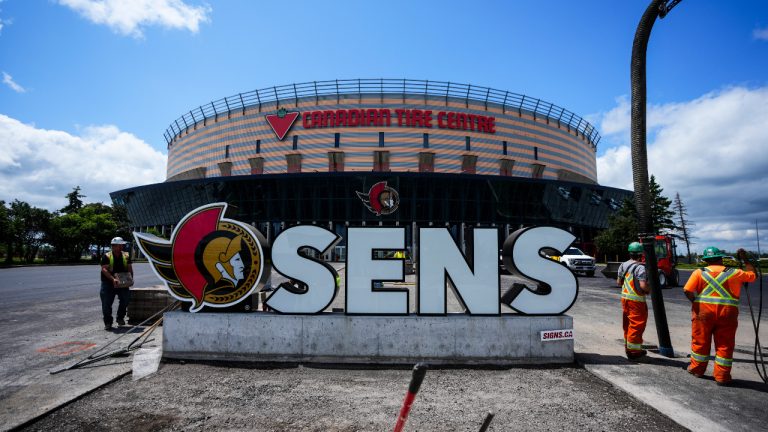 Landscapers work around Ottawa Senators NHL team signage at the Canadian Tire Centre in Ottawa on Tuesday, June 13, 2023.  (Sean Kilpatrick/CP)