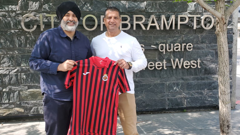 Canadian entrepreneur Steve Nijjar (right) alongside Brampton deputy mayor Harkirat Singh, holding a Racing Madrid jersey. Nijjar is co-owner of the Spanish side, which he hopes to help rise up from the lower tiers of Spanish soccer. (CP/handout)