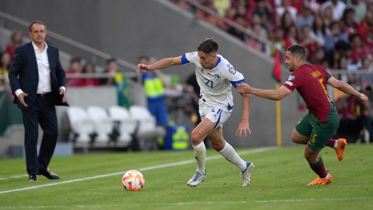 Portugal's Raphael Guerreiro, right, challenges for the ball with Bosnia's Amar Dedic during the Euro 2024 group J qualifying soccer match between Portugal and Bosnia and Herzegovina, at the Luz Stadium in Lisbon, Portugal, Saturday, June 17, 2023. (AP Photo/Armando Franca)