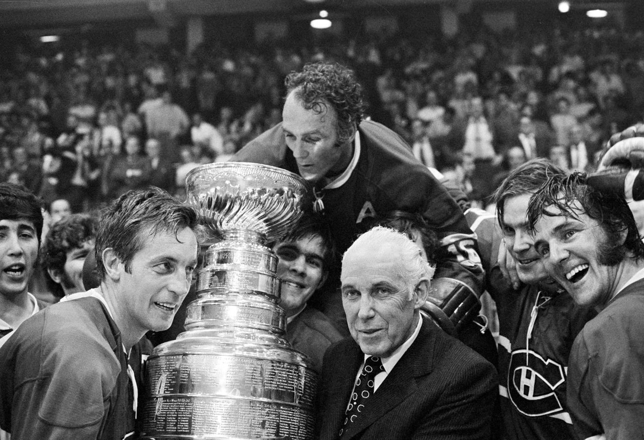 Montreal Canadiens' Henri Richard, center, who scored the game-winning goal, peers into the Stanley Cup held by team captain Jean Beliveau, left, and NHL Commissioner Clarence Campbell in Chicago, Ill., Tuesday night, May 18, 1971. Longtime Montreal Canadiens centre Henri Richard died on Friday. He was 84. THE CANADIAN PRESS/AP