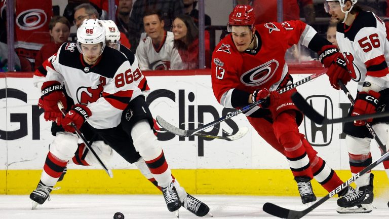 New Jersey Devils' Jack Hughes (86) controls the puck in front of Carolina Hurricanes' Jesse Puljujarvi (13) during the third period of Game 2 of an NHL hockey Stanley Cup second-round playoff series in Raleigh, N.C., Friday, May 5, 2023. (Karl B DeBlaker/AP)