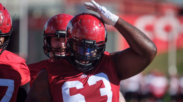 Calgary Stampeders' Derek Dennis adjusts his helmet on opening day of training camp. (Jeff McIntosh/CP)