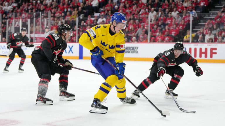 Sweden's Filip Bystedt, second from right, protects the puck from Canada's Olen Zellweger, right, and Ethan Del Mastro during first period IIHF World Junior Hockey Championship action in Halifax, Saturday, Dec. 31, 2022. (Darren Calabrese/CP)