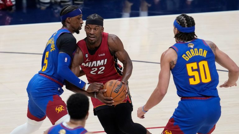 Miami Heat forward Jimmy Butler (22) is defended by Denver Nuggets guard Kentavious Caldwell-Pope, left, during the first half of Game 1 of basketball's NBA Finals, Thursday, June 1, 2023, in Denver. (David Zalubowski/AP)