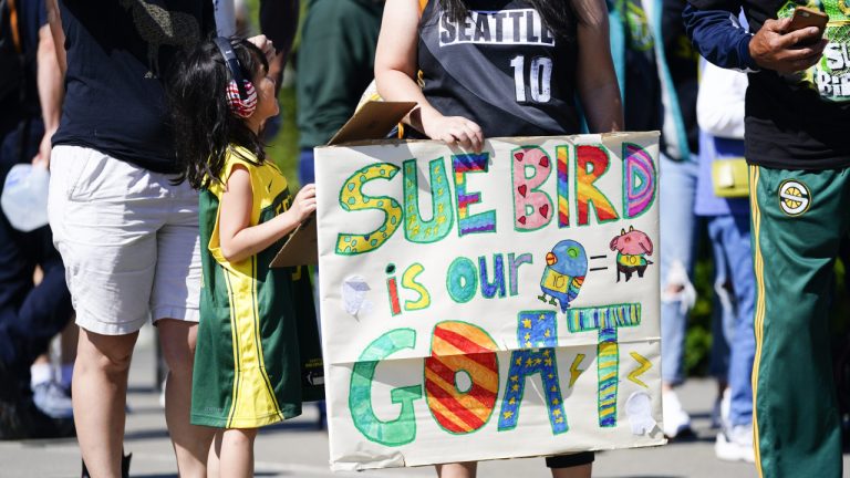 Vicky Chiong, 6, holds a Sue Bird sign with Olivia Chiong as they wait to enter Climate Pledge Arena before a WNBA basketball game between the Seattle Storm and the Washington Mystics, Sunday, June 11, 2023, in Seattle. Bird's jersey is set to be retired during a postgame ceremony. (Lindsey Wasson/AP)