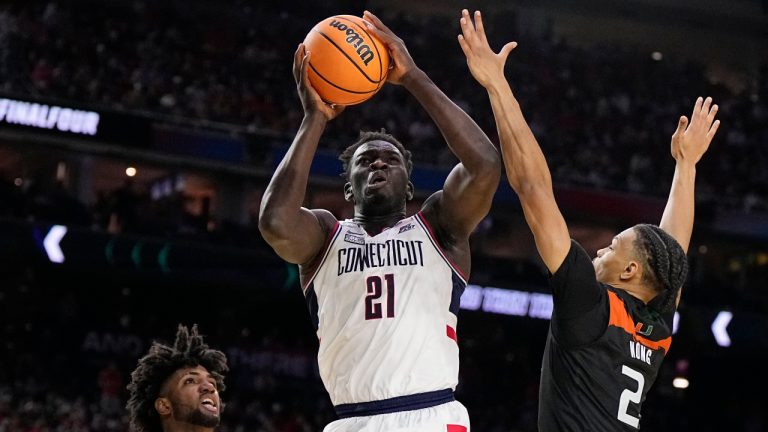 Connecticut forward Adama Sanogo scores past Miami guard Isaiah Wong during the second half of a Final Four college basketball game in the NCAA Tournament on Saturday, April 1, 2023, in Houston. (Brynn Anderson/AP)