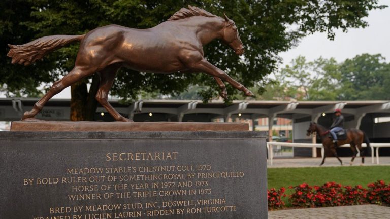 A statue dedicated to 1973 Triple Crown winner Secretariat stands in the paddock as a horseman rides his mount through the ring ahead of the Belmont Stakes horse race. (John Minchillo/AP)