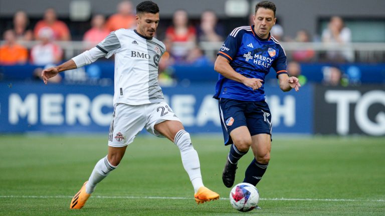 Toronto FC defender Raoul Petretta (28) and FC Cincinnati's Santiago Arias (13) vie for the ball during the first half of an MLS soccer match Wednesday, June 21, 2023, in Cincinnati. (Jeff Dean/AP)