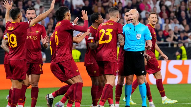 Roma players talk to Referee Anthony Taylor before he checks the VAR for a possible penalty during the Europa League final soccer match between Sevilla and Roma, at the Puskas Arena in Budapest, Hungary, Wednesday, May 31, 2023. (Petr David Josek/AP)