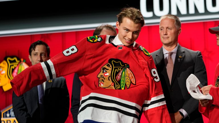 Connor Bedard puts on a Chicago Blackhawks jersey after being picked by the team during the first round of the NHL hockey draft Wednesday, June 28, 2023, in Nashville, Tenn. (AP)