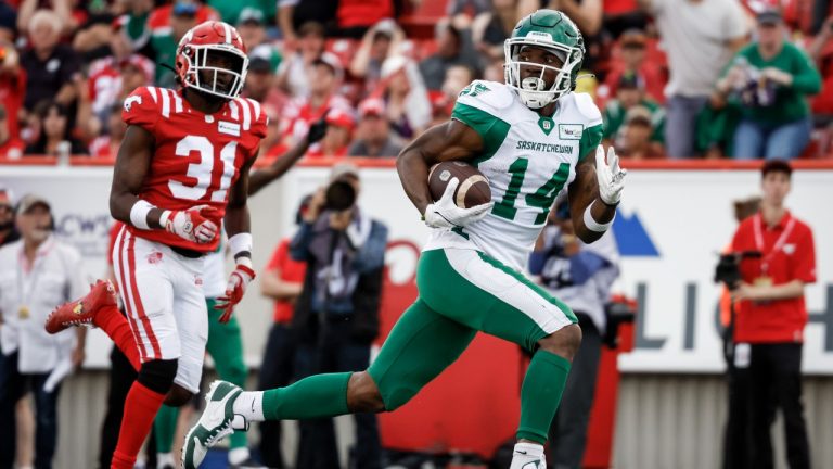 Saskatchewan Roughriders wide receiver Tevin Jones, right, runs in a touchdown as Calgary Stampeders defensive back Tre Roberson looks on during second half CFL football action in Calgary, Alta., Saturday, June 24, 2023. (Jeff McIntosh/CP)