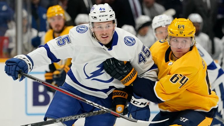 Tampa Bay Lightning forward Cole Koepke (45) and Nashville Predators center Mikael Granlund (64) chase the puck during the first period of an NHL preseason hockey game Friday, Sept. 30, 2022, in Nashville, Tenn. (Mark Humphrey/AP)