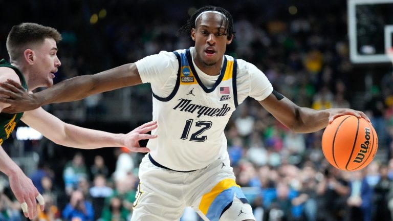 Marquette forward Olivier-Maxence Prosper (12) drives on Vermont guard Robin Duncan (55) in the first half of a first-round college basketball game in the NCAA Tournament on March 17, 2023, in Columbus, Ohio. (Paul Sancya/AP)