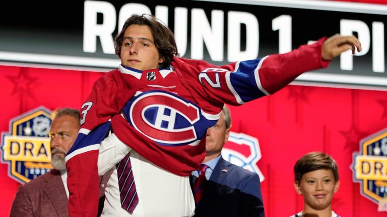 David Reinbacher puts on a Montreal Canadiens jersey after being picked by the team during the first round of the NHL hockey draft Wednesday, June 28, 2023, in Nashville, Tenn. (George Walker IV/AP Photo)