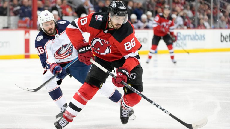 New Jersey Devils defenseman Kevin Bahl (88) skates in front of Columbus Blue Jackets right wing Kirill Marchenko (86) during the third period of an NHL hockey game Thursday, April 6, 2023, in Newark, N.J. The Devils won 8-1. (AP Photo/Mary Altaffer) 