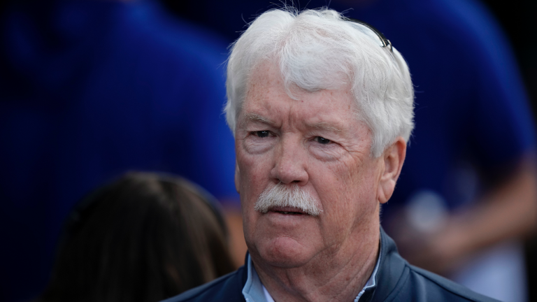 Kansas City Royals owner John Sherman watches from the dugout before a baseball game against the Cincinnati Reds Monday, June 12, 2023, in Kansas City, Mo. (AP Photo/Charlie Riedel)