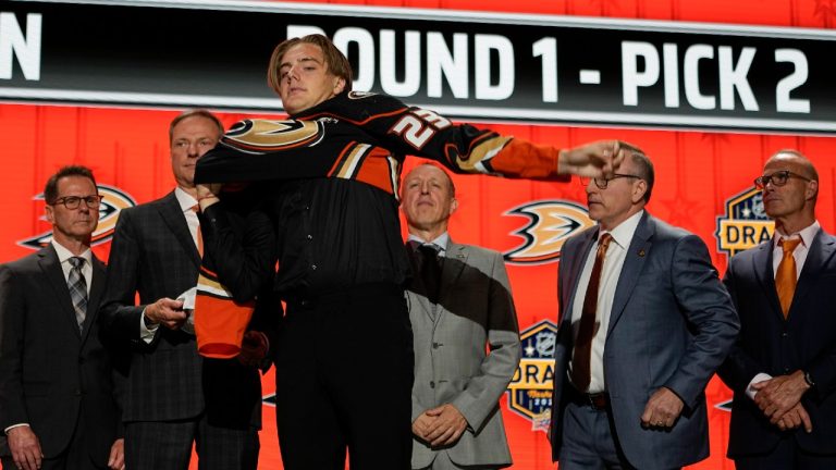 Leo Carlsson puts on an Anaheim Ducks jersey after being picked by the team during the first round of the NHL hockey draft Wednesday, June 28, 2023, in Nashville, Tenn. (George Walker IV/AP)