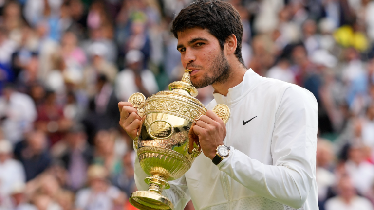 Spain's Carlos Alcaraz celebrates with the trophy after beating Serbia's Novak Djokovic to win the final of the men's singles on day fourteen of the Wimbledon tennis championships in London, Sunday, July 16, 2023. (AP)