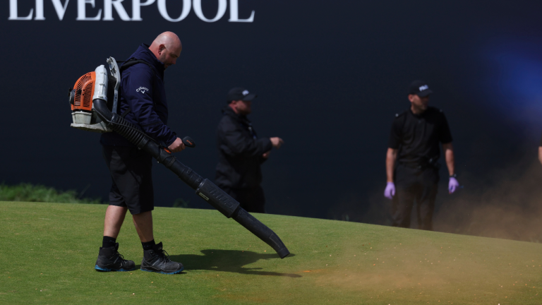 Green-keeprs and staff clear the remains of material thrown onto the 17th green area by Just Stop Oil protesters during the second day of the British Open Golf Championships at the Royal Liverpool Golf Club in Hoylake, England, Friday, July 21, 2023. (AP Photo)