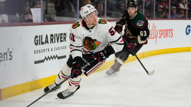 Chicago Blackhawks defenseman Ian Mitchell (51) skates away from Arizona Coyotes left wing Matias Maccelli in the third period during an NHL hockey game, Tuesday, Feb. 28, 2023, in Tempe, Ariz. Arizona won 4-1. (AP Photo/Rick Scuteri) 