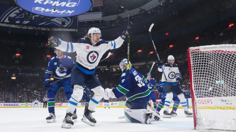 Winnipeg Jets' Axel Jonsson-Fjallby, front left, of Sweden, celebrates his goal against Vancouver Canucks goalie Spencer Martin (30) during the third period of an NHL hockey game in Vancouver, on Saturday, December 17, 2022. (Darryl Dyck/CP)