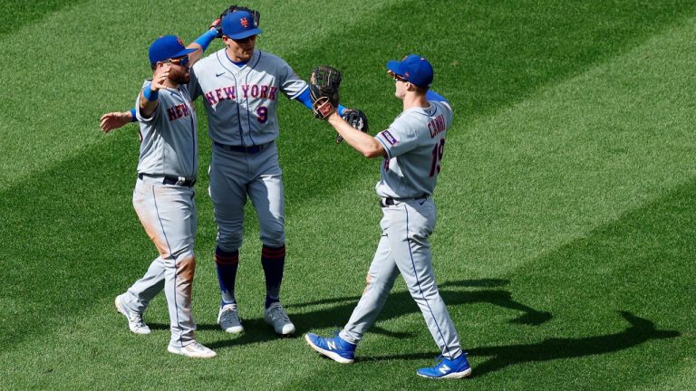 New York Mets' Mark Canha (19), Brandon Nimmo (9) and DJ Stewart celebrate after defeating the Boston Red Sox during the continuation of a suspended baseball game, Saturday, July 22, 2023, in Boston. The game was suspended the night before due to heavy rain. (Michael Dwyer/AP)