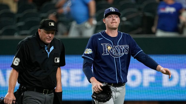 Tampa Bay Rays relief pitcher Pete Fairbanks, right, walks past home plate umpire Ron Kulpa, left, on his way to the dugout after allowing Texas Rangers' Josh Smith to score from third on a wild pitch in the ninth inning of a baseball game, Monday, July 17, 2023, in Arlington, Texas. (Tony Gutierrez/AP Photo)