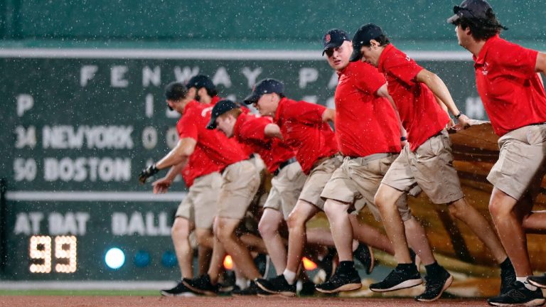 The Fenway Park grounds crews pulls out a tarp during a rain delay in the fourth inning of a baseball game between the Boston Red Sox and the New York Mets, Friday, July 21, 2023, in Boston. (Michael Dwyer/AP)